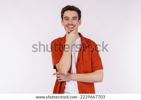 Portrait of young handsome man looking confident at the camera with smile with crossed arms and hand raised on chin over isolated background. Thinking positive concept.