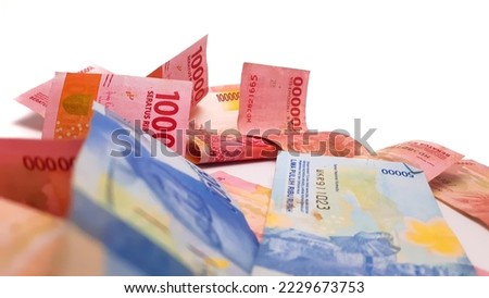 One hundred thousand rupiah and fifty thousand rupiah were scattered, Indonesian currency, isolated against white background.
