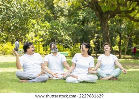 Group of indian senior people wearing white cloths relaxing and laughing together outdoor at summer park. healthy lifestyle, Retirement life. Royalty-Free Stock Photo #2229681629