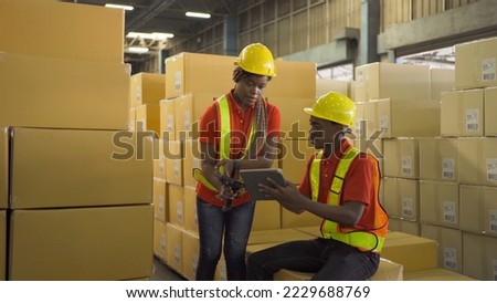 Team of a couple of black worker working in large warehouse retail store industry. Rack of stock storage. Interior of cargo in ecommerce and logistic. Depot. People lifestyle. Shipment service.