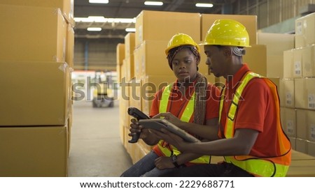 Team of a couple of black worker working in large warehouse retail store industry. Rack of stock storage. Interior of cargo in ecommerce and logistic. Depot. People lifestyle. Shipment service.