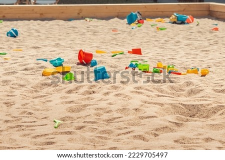 Toys are scattered in a large children's sandbox. Childhood and leisure of kids Royalty-Free Stock Photo #2229705497