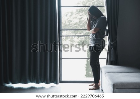 Schizophrenia with lonely and sad in mental health depression concept. Depressed woman standing against with dark room feeling miserable at home . Women are depressed, fearful and unhappy. Royalty-Free Stock Photo #2229706465