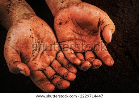 Hands dirty with clay , soil background