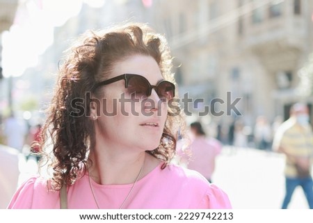A brunette woman walks through the streets and park in the city Istanbul on a summer sunny day
