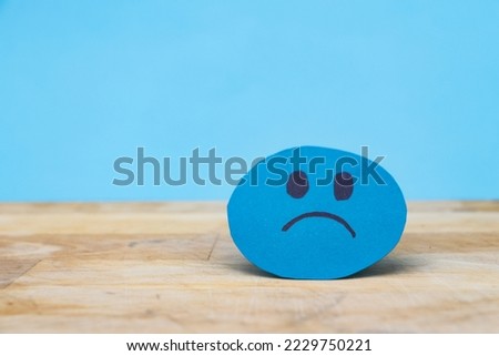 blue angry face paper. Emotional intelligence, balance emotion control, mental health assessment, bipolar disorder concept