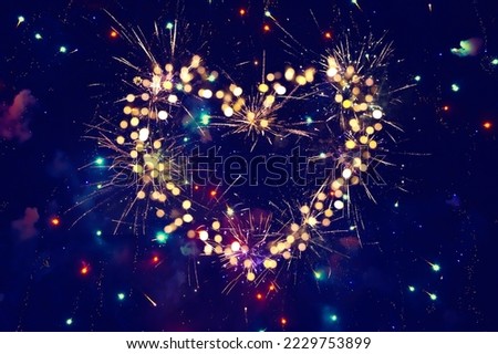 Beautiful Holiday background for Valentine's Day, New Year. Decorative heart of fireworks on night sky background. Abstract template with copy space for design flyer, greeting card. Love concept