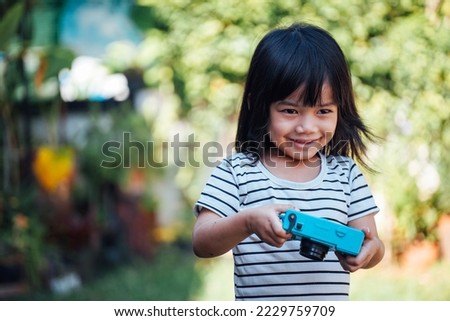 Asian children are taking pictures with a DSLR. 