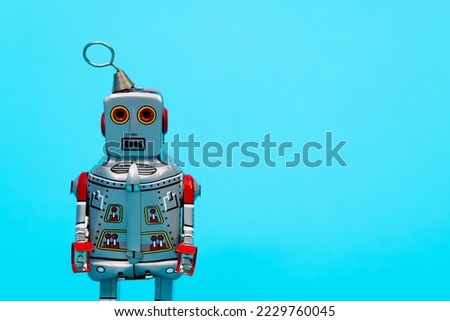 Retro robot toy on blue background.