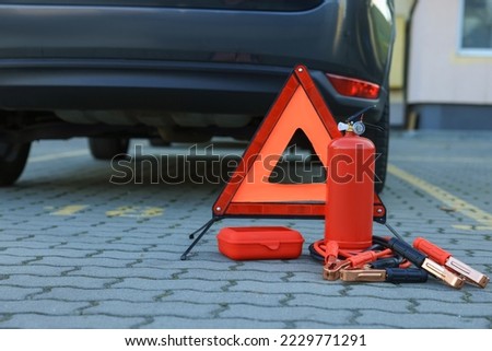Emergency warning triangle and safety equipment near car, space for text Royalty-Free Stock Photo #2229771291