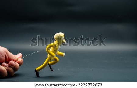 Process of running stopmotion. Start of running. Man's hand holding with aluminum wire a figure created with modeling paste. The 12 principles of animation. Royalty-Free Stock Photo #2229772873