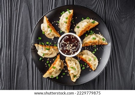 delicious fried gyoza dumplings on a black plate. Royalty-Free Stock Photo #2229779875