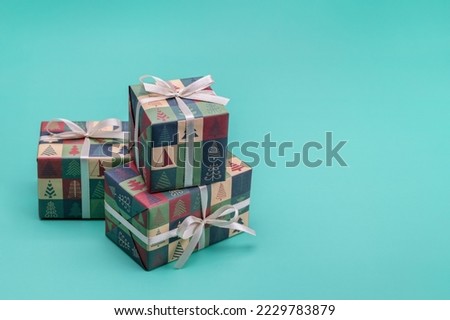 Gifts in boxes wrapped in paper with Christmas and New Year pictures. Happy Holidays.