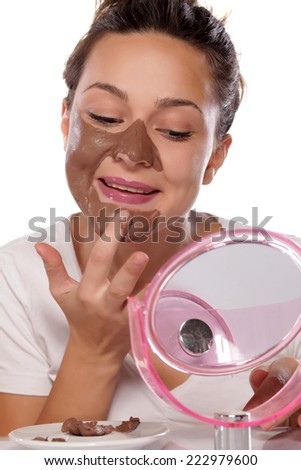 young woman enjoys applying face mask