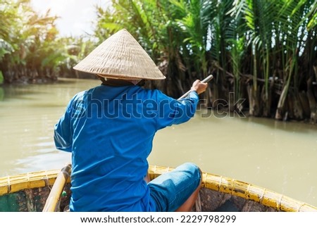 Man rowing a basket boat, along the coconut river forest, a unique Vietnamese at Cam thanh village. Landmark and popular for tourists attractions in Hoi An. Vietnam and Southeast Asia travel concepts Royalty-Free Stock Photo #2229798299