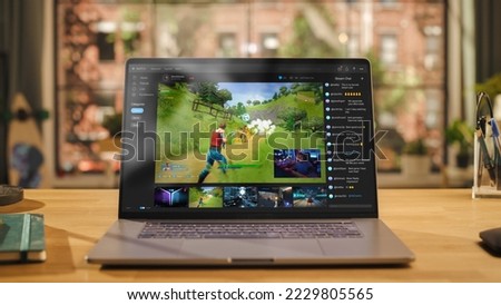 Laptop Computer Display with Game Live Streaming Platform Standing on Wooden Table with a Notebook in Living Room. Famous Influencer Trying a Newly Released Game Online and Sharing his Screen