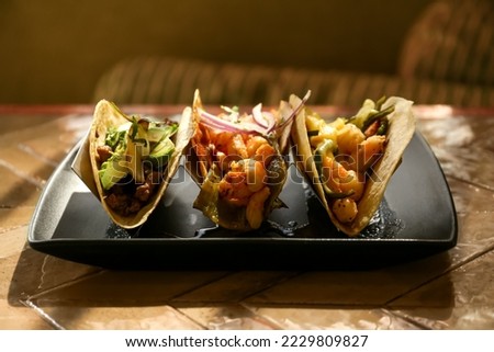 Delicious tacos with shrimps and vegetables on table