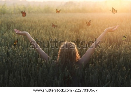 surreal encounter between a woman and free butterflies flying in the middle of nature