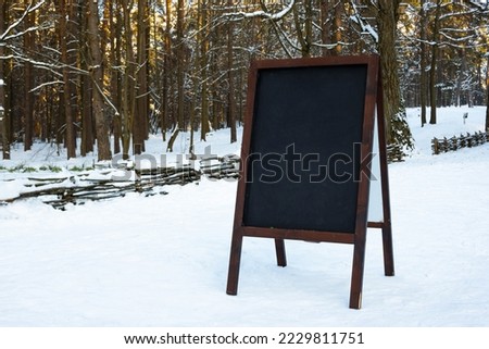 Close up of chalkboard menu outside on the snow. Winter menu display in the mountains.