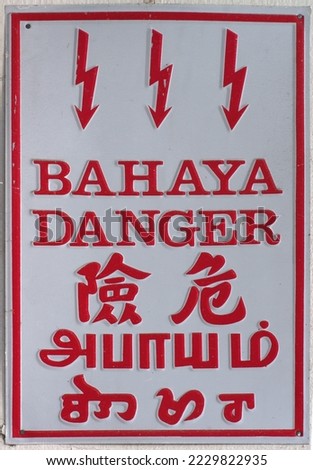 Multilingual warning sign on electrical fuse box with the word "Danger" in Malay, English, Chinese, Tamil and Thai. 