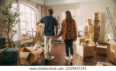 Family New Home Moving in: Happy and Excited Young Couple Enter Newly Purchased Apartment. Beautiful Family Happily Holding Hands. Modern Home Ready for Decorations