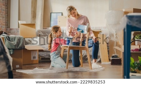 Moving in and Home Renovations: Happy Mother and Daughter Painting Vintage Furniture Chair for New Cozy Home. Cheerful Young Family Make Apartment Comfortable with Art, Color and Vintage Furniture Royalty-Free Stock Photo #2229835253