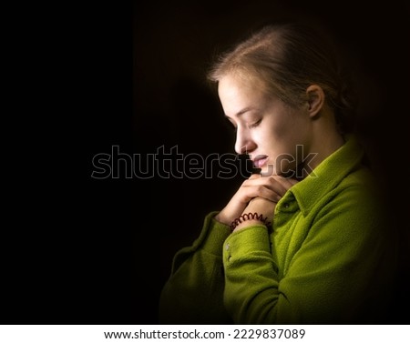 Dramatic evangelical pentecostal pious mourn pretty young light white lady kneeling ask implore wish upwards Jesus Christ. Vintage think life concept copyspace with space for text on dark backdrop