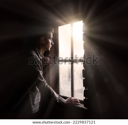 Old retro antique life young teen age frown boy guy face feel guilt light sky view. ancient lost tire guilty human cry ask belief god lord Christ love faith hand dark black room text space war concept Royalty-Free Stock Photo #2229837121