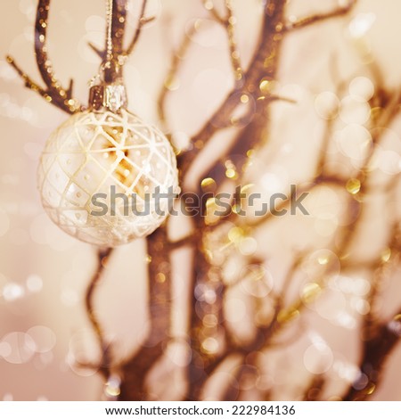 Blurred picture of white snowy Christmas decoration with baubles on the branch. Nice bokeh lights, instagram vintage effect.