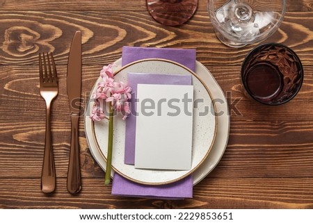 Table setting with blank card and hyacinth flower on wooden background