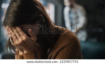 Portrait of Crying Woman Covering Her Face with Hands, being Harrased and Bullied by Violent Partner. Couple Arguing, Fighting, Domestic Abuse, Toxic Masculinity. Rack Focus with Boyfriend Screaming Royalty-Free Stock Photo #2229857755