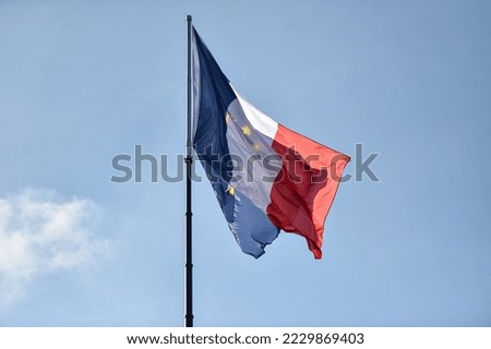 France and European Union flags on a pole are blown by the wind. Blue sky on background 