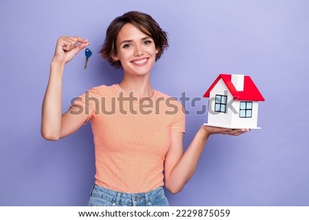 Photo of dreamy cute lady wear striped t-shirt rising new home keys empty space isolated violet color background