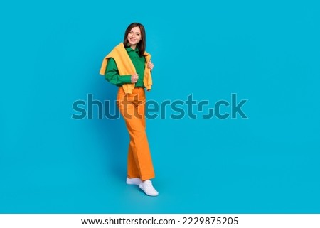 Full length photo of satisfied girlfriend wear comfort clothes enjoy walking autumn weather empty space isolated on blue color background