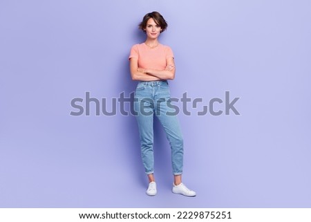Full length photo of shiny confident girl dressed orange t-shirt hands crossed smiling isolated purple color background