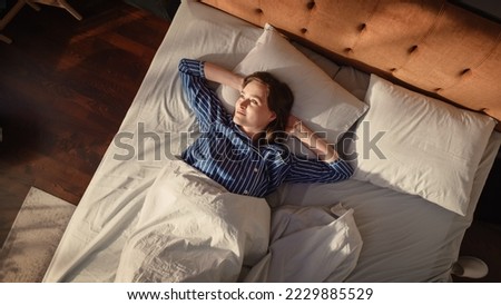 Top View Home: Beautiful Young Woman Sleeps in Her Bed, Sun Shines on Her and She Opens Eyes and Greets New Sunny Day. Joyful Waking Up of a Girl Ready for Productive Day. Top Down Above Shot