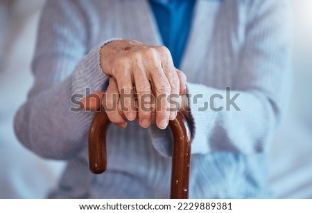 Hands, cane and disability with a senior woman closeup in her home alone with a walking stick for mobility. Health, medical and wellness with a mature female in a retirement home with hand wrinkles Royalty-Free Stock Photo #2229889381