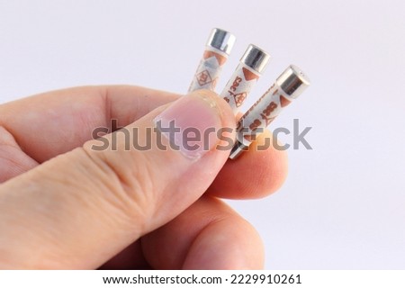 Hand holding electric fuses on a white background close-up.Soft focus.