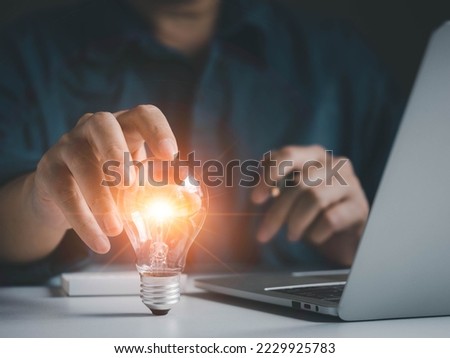 Innovation creativity ideas imagination and inspiration concept. Business man hand touch light bulb with warm light. Genius is thinking on new invention for glowing in business.