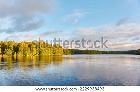 Panoramic view of the forest lake. Clear blue sky with dramatic glowing clouds after the rain. Early autumn landscape. The biggest lake in Tampere area, Nasijarvi, Finland. Nature, environment themes Royalty-Free Stock Photo #2229938493