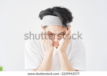 Asian man washing his face in white background
