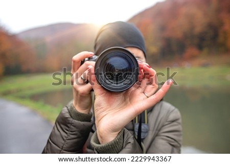 Girl with a dslr camera outdoors in the cold season.