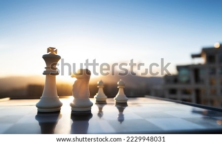 Chess king, knight and pawns on city background.