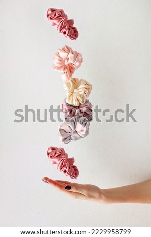 levitation of Colorful silk Scrunchies on woman hand isolated white. Hairdressing tools and accessories. Hair Scrunchies, Elastic HairBands, flying or falling Scrunchie Hairband for girl. copy space Royalty-Free Stock Photo #2229958799
