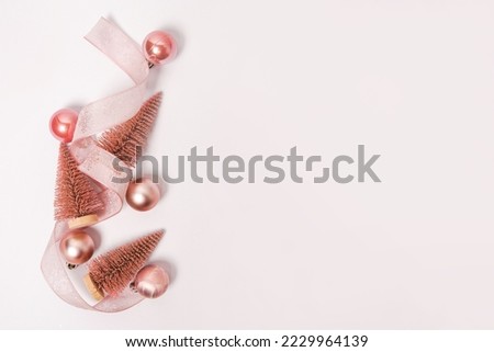 Pink Christmas trees and baubles decoration on white background with copy space. New Year greeting card. Flat lay