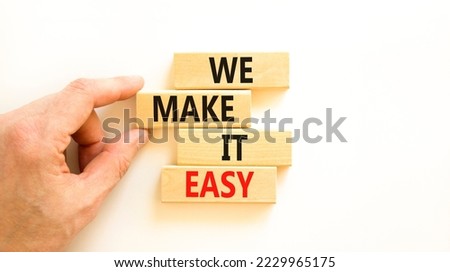 We make it easy symbol. Concept words We make it easy on wooden cubes. Beautiful white table white background. Businessman hand. Business motivational we make it easy concept. Copy space.