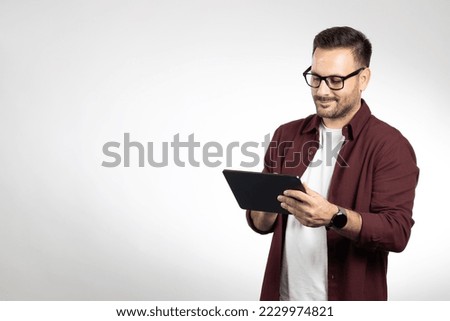 Casual dressed business man using laptop. Portrait taken in studio on white background