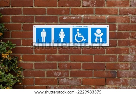 accessible Restroom wayfinding icon sign blue on a outside brick wall