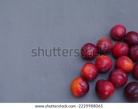 Plumbs fresh ripe fruit on gray background overhead medium shot selective focus