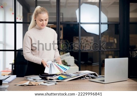 Online color matching process for wall paint for interior design. Designer works with client via Internet laptop. Royalty-Free Stock Photo #2229996841
